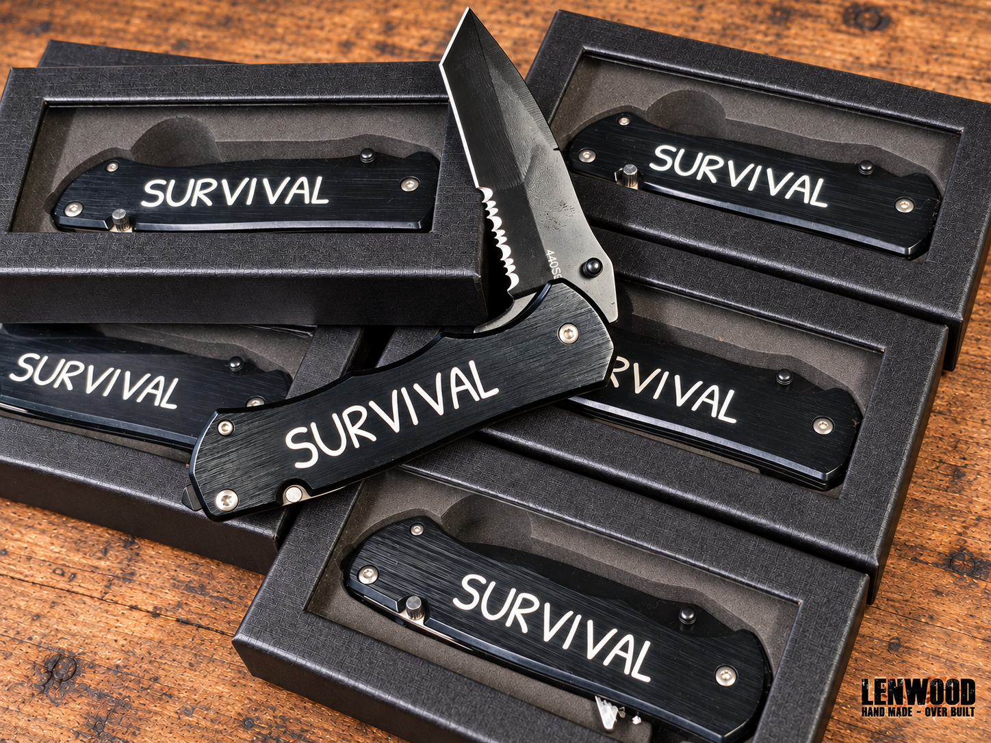 Lenwood Survival folding knife shown open with serrated blade, pocket clip, and Lenwood blade engraving on black presentation boxes.